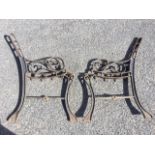 A pair of cast iron bench ends with channelled frames, the arms on pierced scrolled supports, raised