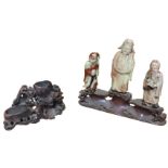 A nineteenth century carved soapstone group with three deities standing on naturalistic carved