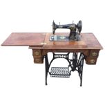 A late Victorian Singer sewing machine in folding walnut table with flip moulded top on cast iron