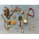 A small tin of jewellery including brooches, earclips, an Accurist wristwatch, bracelets, beads,