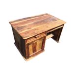 A hardwood desk with rectangular rounded moulded top above a drawer and panelled door cupboard