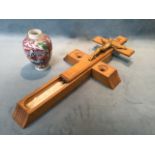 An oak absolution crucifix with sliding case revealing holy water bottle, and a pair of candles to