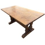 A rectangular oak coffee table on pierced trestle style supports joined by pegged stretcher, with