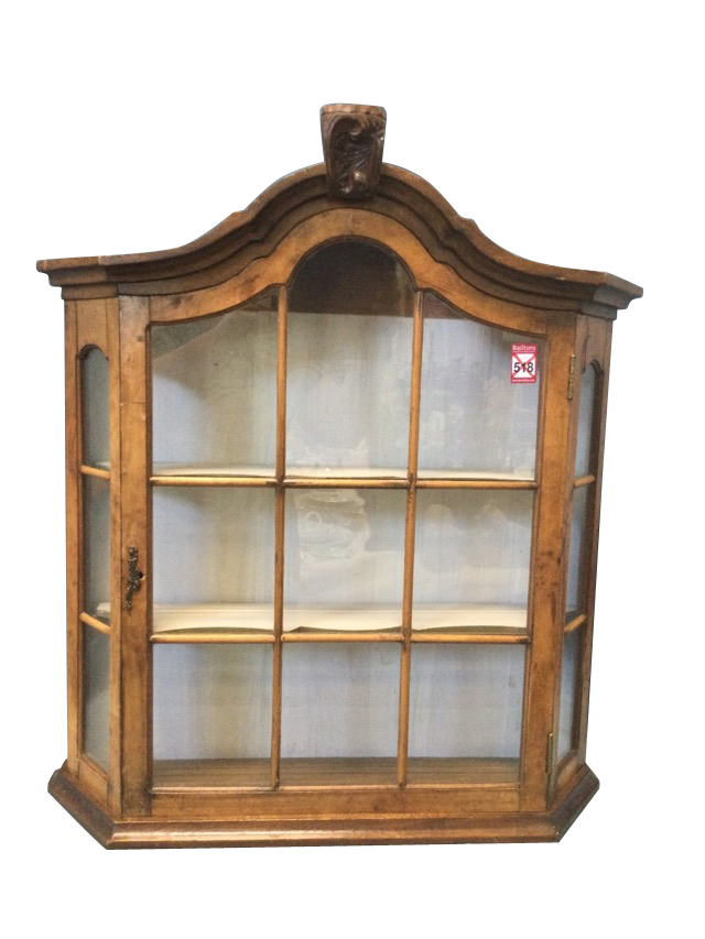 A walnut display cabinet with carved arched moulded cornice above an astragal glazed door