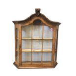 A walnut display cabinet with carved arched moulded cornice above an astragal glazed door