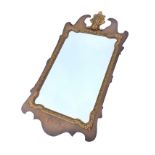 A George II style walnut framed mirror, the pediment with scrolled gilt leaf crest above a shaped