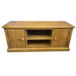 A contemporary oak side cabinet with rectangular top above central open shelves flanked by