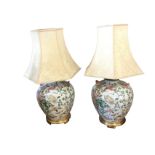 A pair of Chinese porcelain tablelamps decorated in the famile rose palette with floral scrolling,