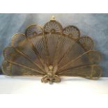 A folding brass fan-shaped peacock firescreen, with tapering rounded pierced panels, on stand with