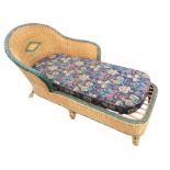 A cane day-bed with rounded double-sided chaise type back above a long latticework seat with loose