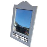 A rectangular painted mirror in an arched frame, with openwork wrought iron grill below. (27.5in x