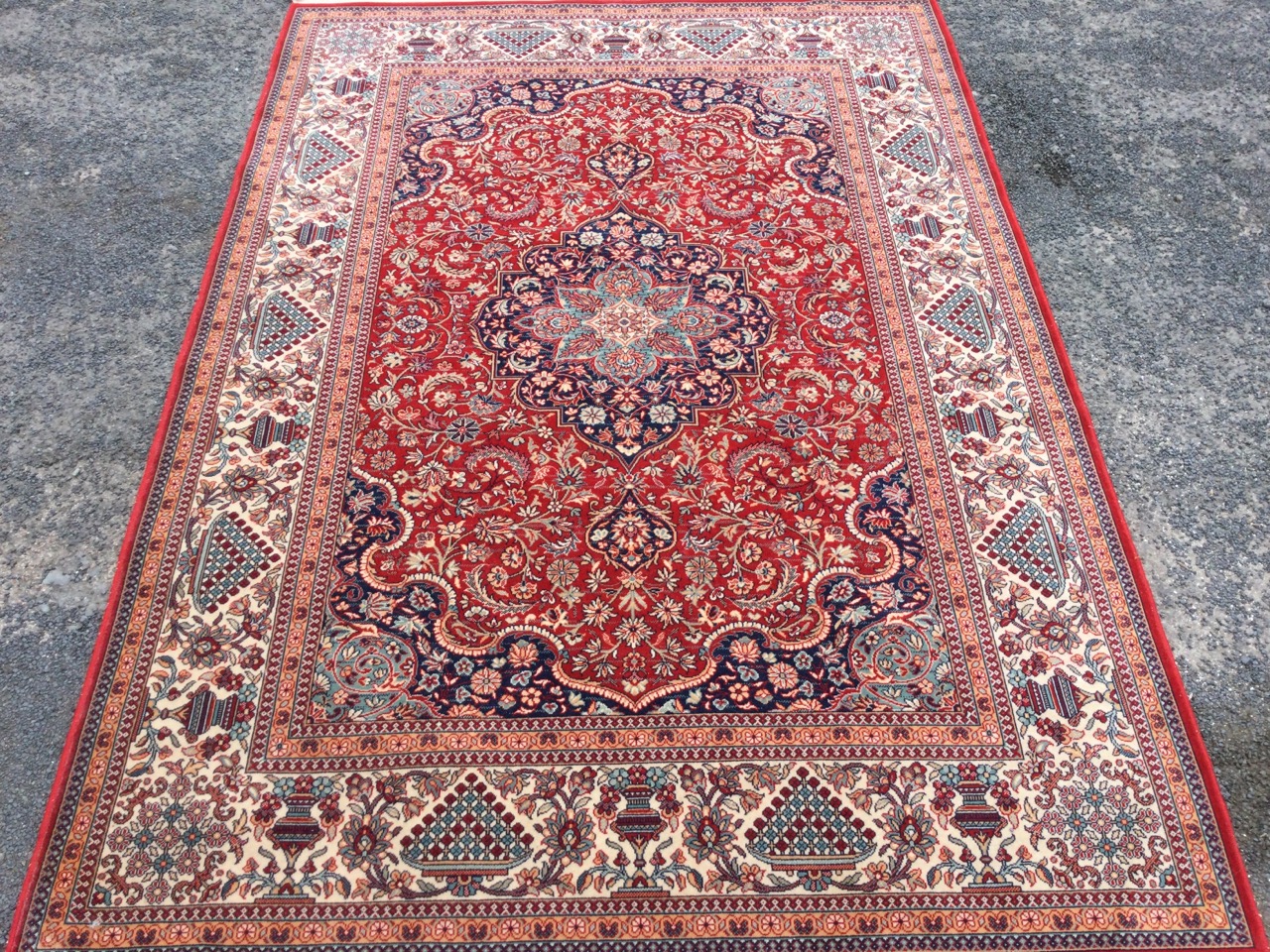 An Indian rug woven with busy red floral field framing a central scalloped blue floral medallion - Image 3 of 3