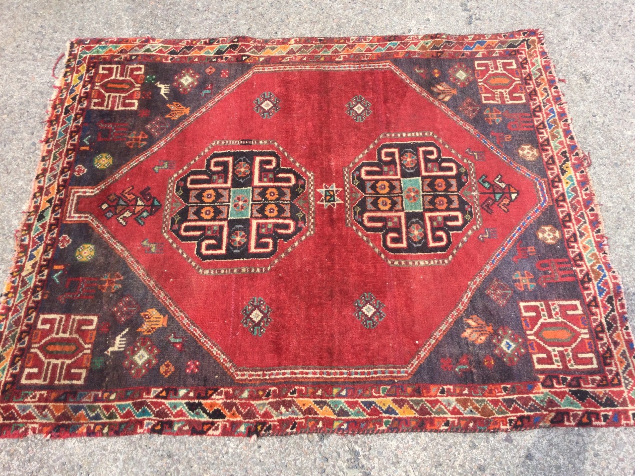 An oriental rug woven with two octagonal hooked medallions on red field having charcoal grey - Image 2 of 3