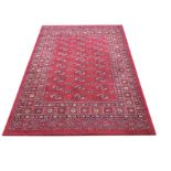 A Tekke oriental style rug woven with field of oval lozenges on madder ground, framed by border of
