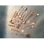 Three hallmarked silver sugar tongs; five hallmarked silver forks; and seven novelty silver spoons -
