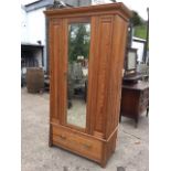 A Victorian pitch pine wardrobe with moulded ogee cornice above a central bevelled mirror door