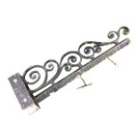 A metal wall bracket for a hanging sign, the 3ft 6in square bar with tapering scrolled crest.