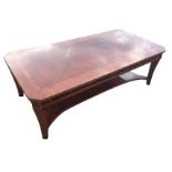 A mahogany coffee table with rectangular crossbanded quarter-veneered canted top above a blind