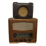 A bakelite cased Bush valve radio with circular speaker beneath glass dial; and a later walnut cased