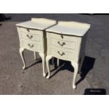A pair of painted bedside cabinets of serpentine outline, having applied leaf moulded decoration