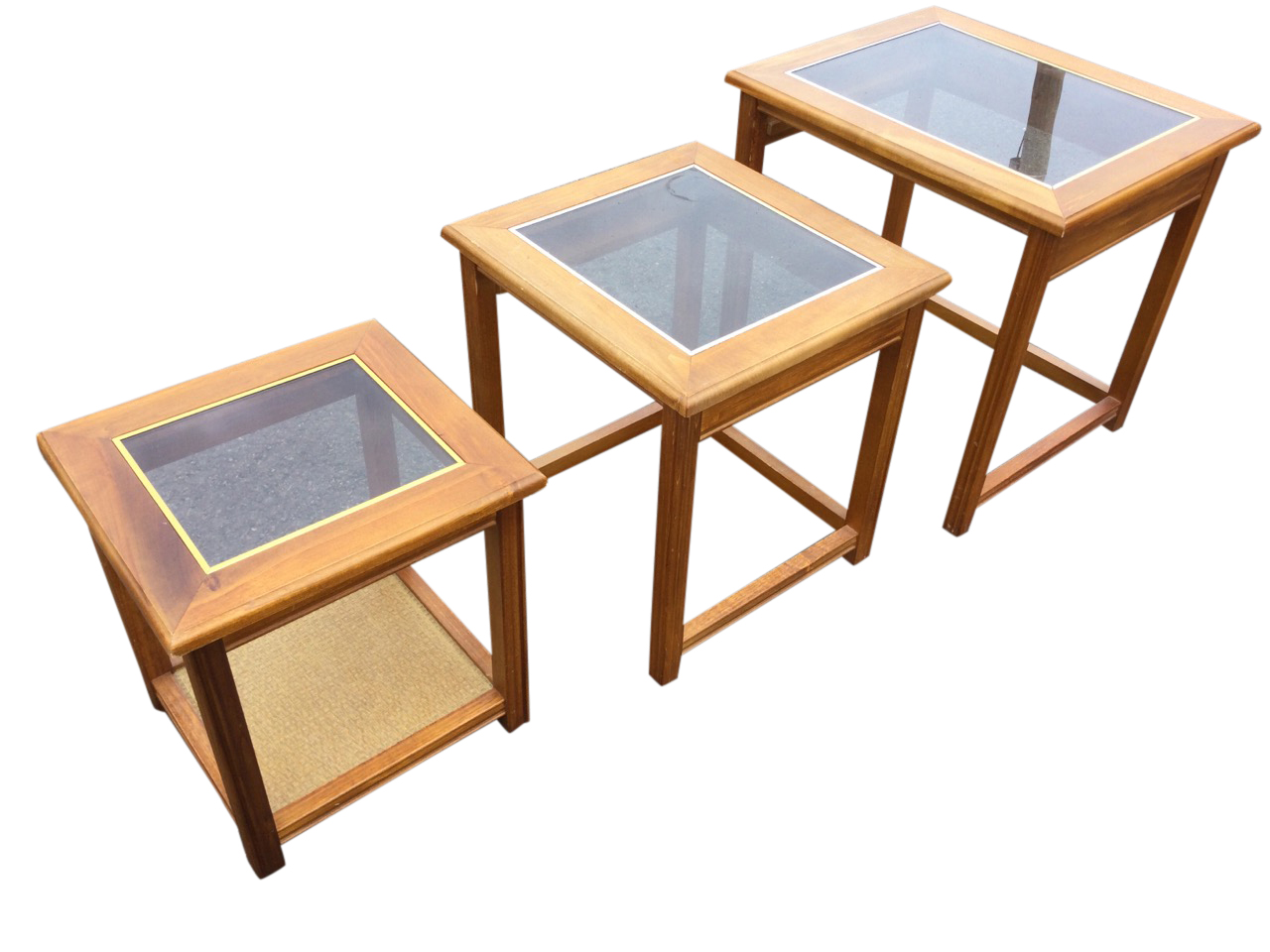 A nest of three 70s coffee tables with rectangular glass panels to moulded tops, raised on square