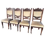 A set of four Victorian carved oak dining chairs, the backs with acanthus scroll carved rails