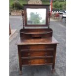 A George VI oak dressing table, the bevelled mirror in egg & dart moulded frame supported on twisted