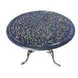 A circular metal garden table, the top with pierced foliate scrolled decoration, raised on three
