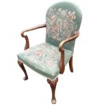 A George II style mahogany armchair with arched padded back above crook arms and sprung