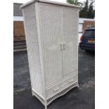 A contemporary painted cane wardrobe with bowfronted ribbed cornice and projected rounded corners,