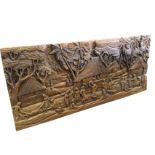 A rectangular carved Balinese panel depicting wedding party to foreground, in front of huts with