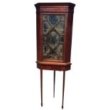 An Edwardian mahogany corner cabinet with moulded cornice above a chequered strung frieze, with