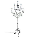 A menorah style wrought iron standard lamp, with scrolled branches supporting five candlelights, the