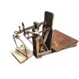 A set of agricultural sack scales on wood stand, having tapering metal weighing table and hanging