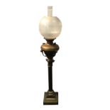 A Victorian brass oil lamp with acid etched globe shade framing glass chimney, the reservoir on