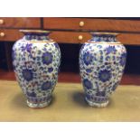A pair of ovoid cloisonné vases decorated with linked blue floral medallions on pale blue ground,