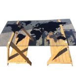 A rectangular contemporary plate glass dining table, the top silhouette printed with a world map,