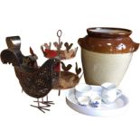 A large stoneware salt glazed bread crock, two ornamental fretwork metal hens, a cicukar egg stand
