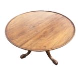 A circular mahogany tray-top table with moulded rim, raised on a turned column with tripartite