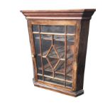 A stained mahogany corner cupboard with moulded cornice above astragal glazed door enclosing