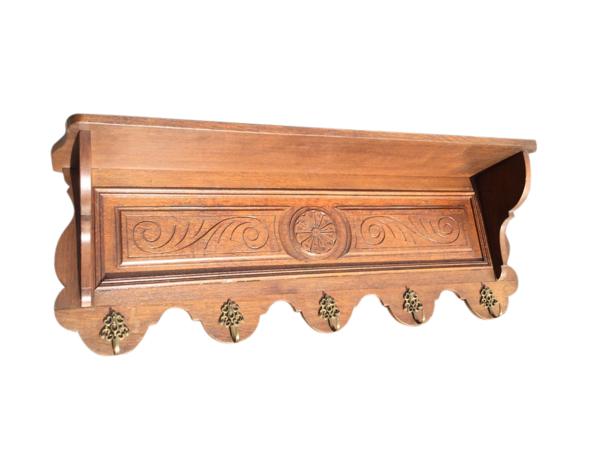 A late Victorian carved coat rack, having shelf on shaped supports above a scroll carved panel, with
