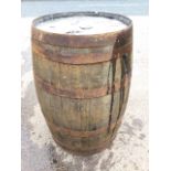 An oak whiskey barrel, the staves bound by six metal riveted strap bands. (34in)