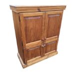 A pine cupboard with moulded cornice above four fielded panelled knobbed doors enclosing shelves,