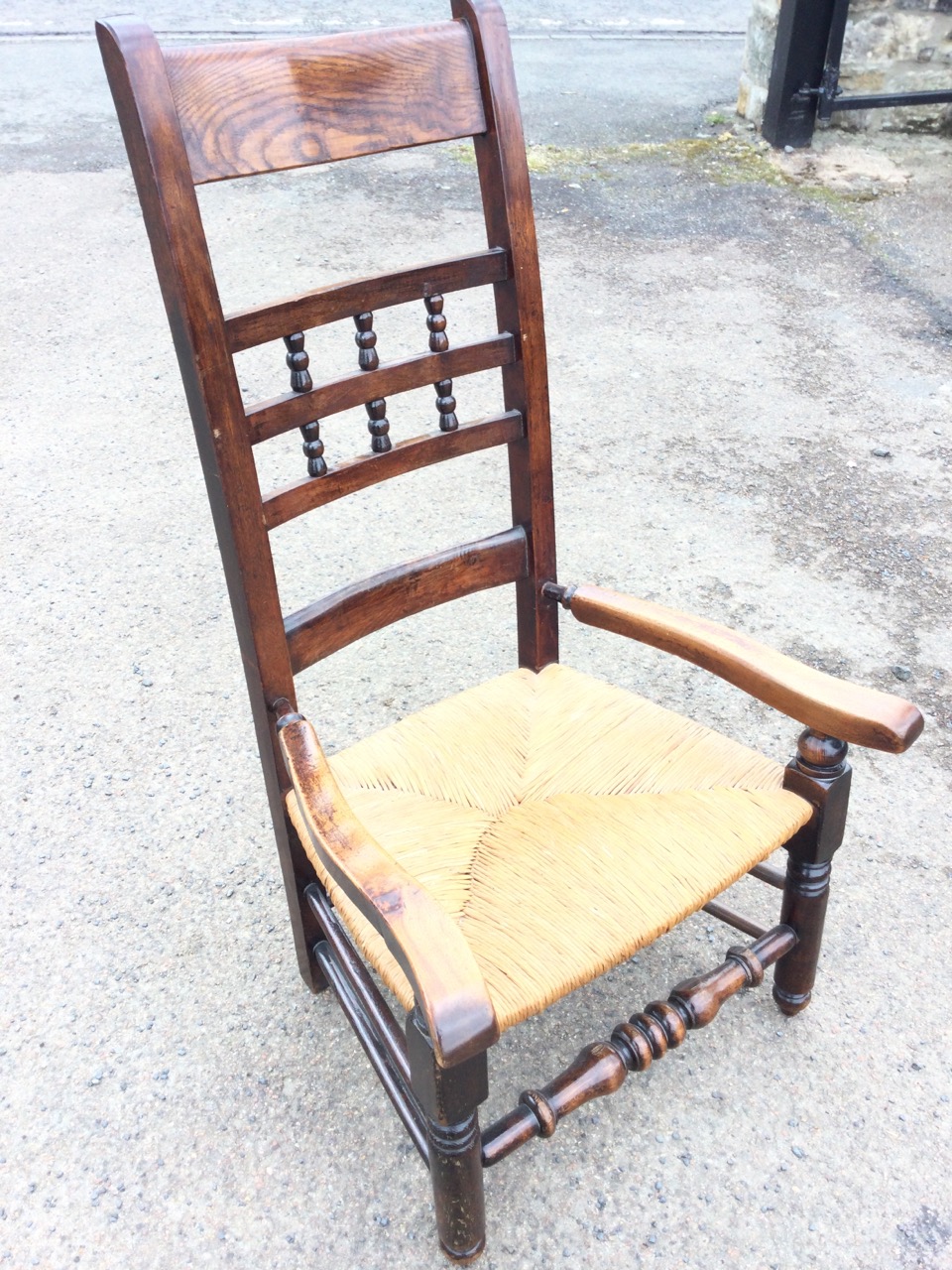 A country oak armchair, the back rails framing turned gallery spindles, above shaped arms and a rush - Image 2 of 3