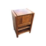 A deco walnut sewing cabinet with hinged cover enclosing a lined interior, with drawer and open