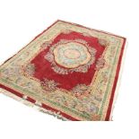 A Chinese thick-pile floral carpet woven with central scalloped medallion framed by ribbon