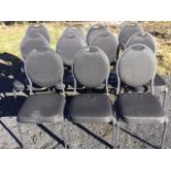 A set of eleven stacking chairs with oval padded backs and cushion seats, raised on square angled