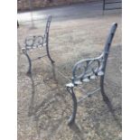 A painted cast iron garden bench, the arms with scrolled supports raised on channelled sabre legs,