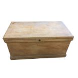 A Victorian pine blanket box of dovetailed construction with later brass carriage handles, the