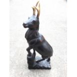 A black forrest style carved stag, the animal raised on rocks with naturalistic base. (24in)